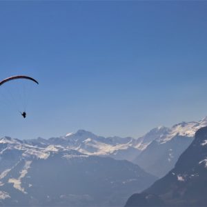 Paraglider vor majestätischer Alpenkulisse mit klarem Himmel – Symbol für Freiheit, Energie und Weitblick.