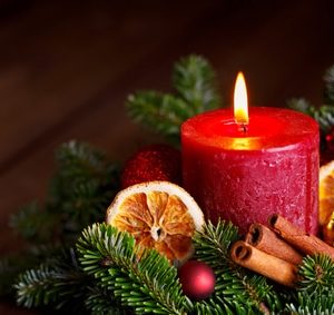 Adventskranz mit roter Kerze, Zimtstangen, Orangenscheiben und Tannenzweigen – stimmungsvolle Weihnachtsdeko mit natürlichen Elementen.