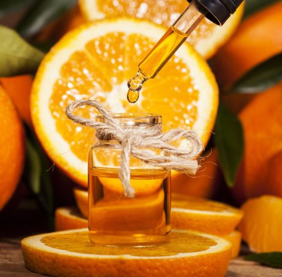 Orangenöl mit aufgeschnittener Orange zur Gewinnung von Organge süß bio (Orangenöl)